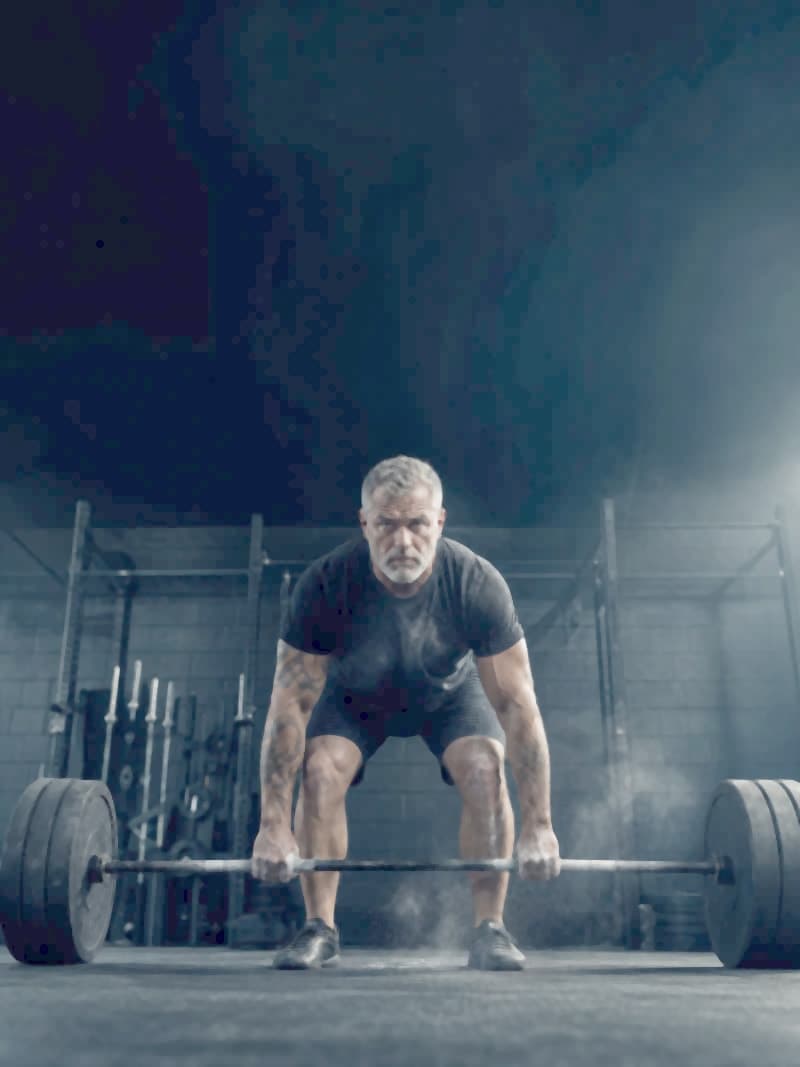 A man mid-lift in a gym